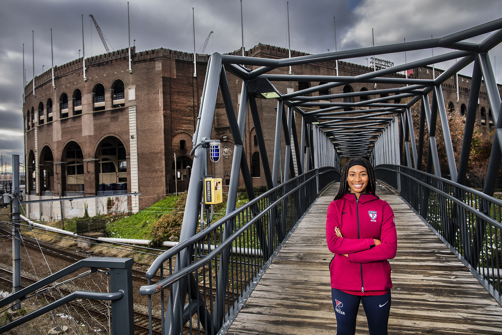 Camillia Nwokedi poses on Paley Bridge behind Franklin Field