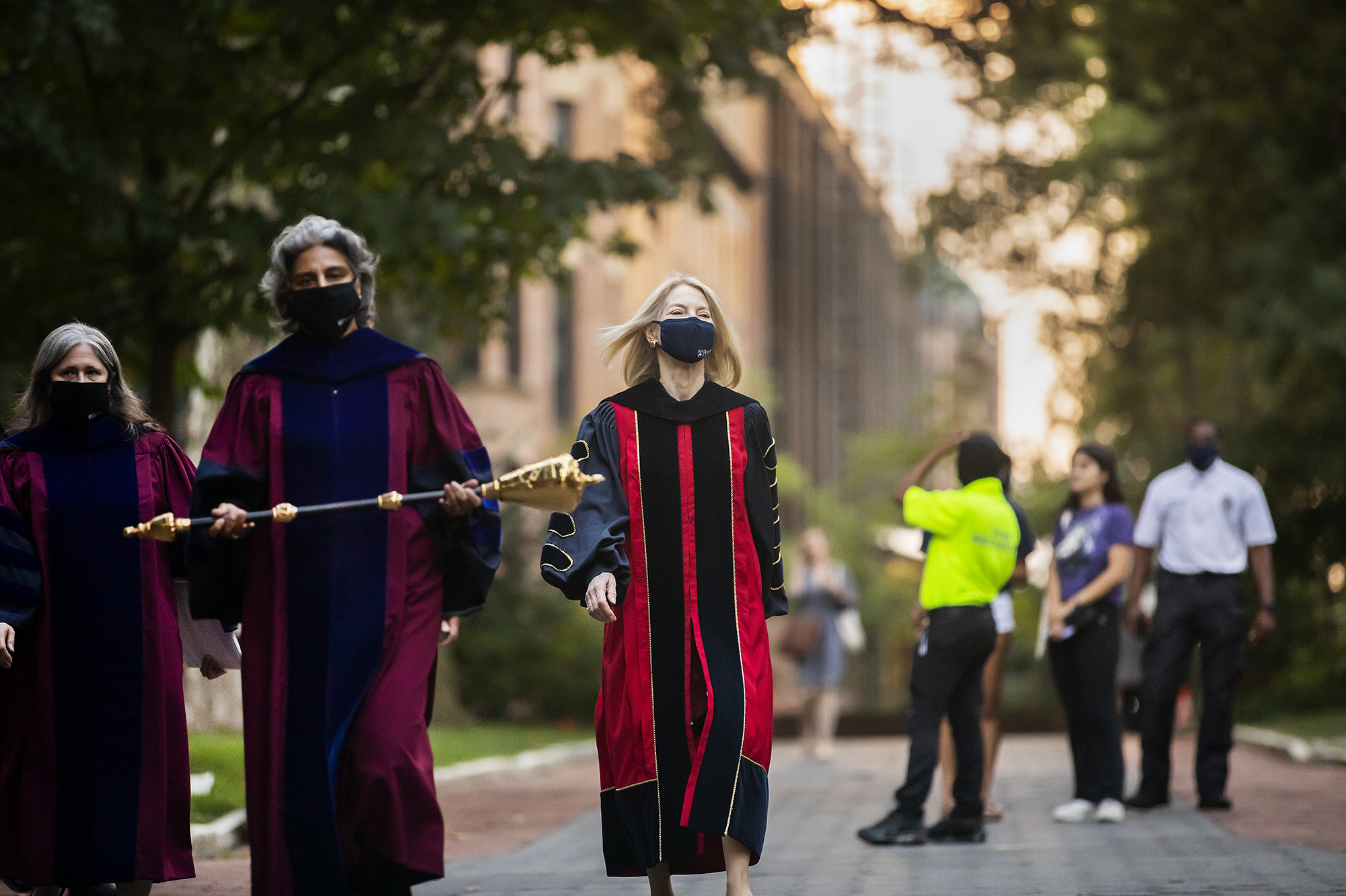 Amy Gutmann in convocation regalia on Locust Walk with Medha Narvekar on her right.