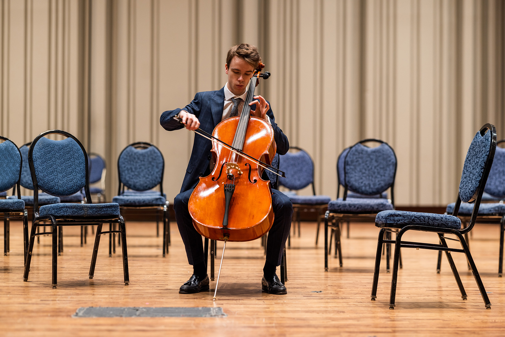 Thomas Sharrock playing the cello on a stage