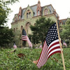 Many small flags placed in the grass on College Green in front of College Hall.
