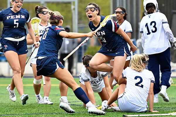 Members of the women's lacrosse team celebrate after scoring a goal against Yale.