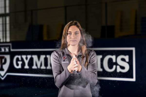 Jordyn Mannino of the gymnastics team claps chalk onto her hands in Hutchingson Gym.