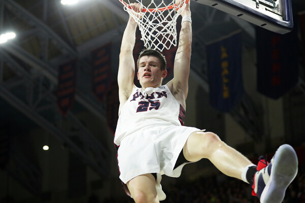 During a game at the Palestra, senior forward A.J. Brodeur hangs on the rim after dunking.