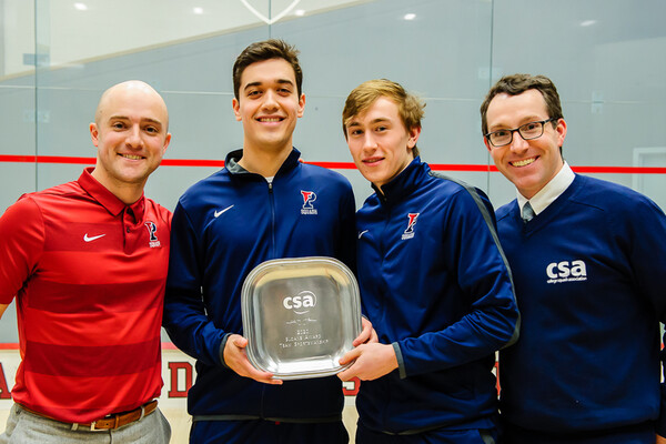 From left, Head Coach Gilly Lane, senior David Yacobucci, and junior Andrew Douglas accept the Sloane Award, along with a College Squash Association official.