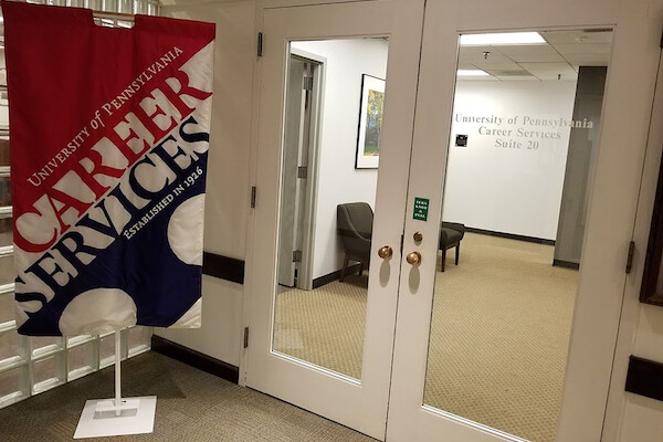 Double doors lead into a waiting area. A large banner to the left reads, "University of Pennsylvania Career Services Established in 1926. 