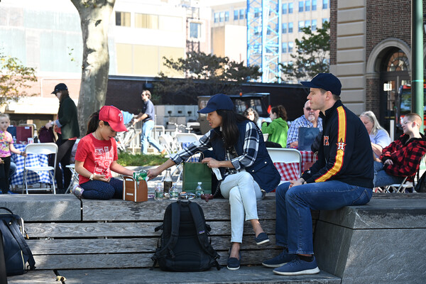 A family having lunch on a bench at Penn’s Friends and Family Day.